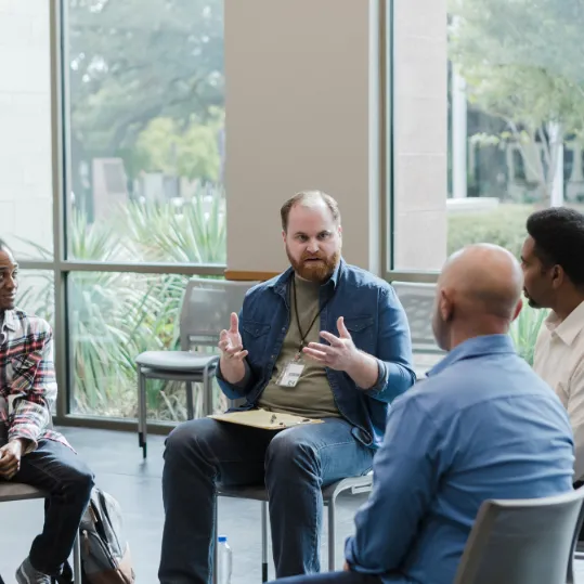 Support group discussion in a counselling setting, representing mental health recovery services and professional support.